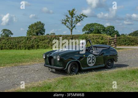 1955 59s Fünfzigerjahre Green Austin Nr.28 modifiziertes Rennauto Benzin 1098 ccm, mit Überrollbügel und Fahrer mit Crashhelm. Austin A30 Speedster offenes Cabriolet mit gekürzter Karosserie. Stockfoto