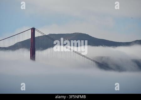 Turm und Kabel der Golden Gate Bridge, die aus dem tiefen Nebel über der Bucht von San Francisco, Kalifornien, USA, auftauchen Stockfoto