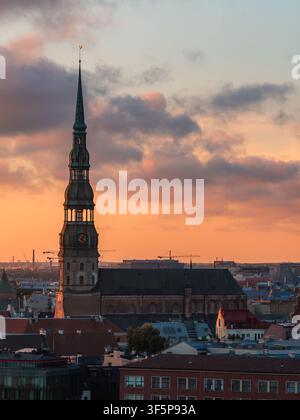 Luftaufnahme des Turms der St.-Petri-Kirche über der Altstadt von Riga bei Sonnenuntergang Stockfoto