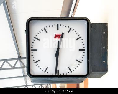 Italien - 3. August 2026: klassischer Platz, doppelseitige Industriewanduhr von einem italienischen Bahnhof, mit der roten FS (Ferrovie dello Stato) Stockfoto