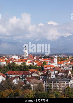 Diese Luftaufnahme zeigt Kranj in Slowenien mit seinen Gebäuden und Dächern vor dem Hintergrund von Bergen. Stockfoto