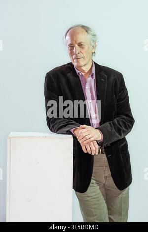 Porträt des amerikanischen Schriftstellers Richard Ford, der sich auf eine weiße Kiste lehnt und eine braune Jacke trägt Stockfoto
