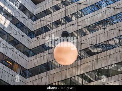 Eine moderne Pendelleuchte verfügt über eine große, mattierte Glasglobe, die an einer schwarzen Leuchte aufgehängt ist Stockfoto