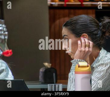 Eine Frau nippt an einem Cocktail in einer Bar Stockfoto