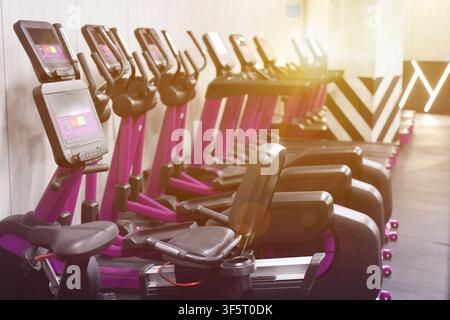 Cardio-Zone mit Fitnessbikes und Laufbändern in einem sonnendurchfluteten Fitnessstudio, selektive Fokussierung Stockfoto