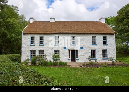 Zweistöckiges traditionelles Strohdachhaus mit blau umrandeten Schiebefenstern im Ulster American Folk Park nahe Omagh, County Tyrone, Nordirland Stockfoto
