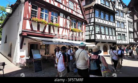 STRASBOURG, FRANKREICH - 15. JUNI 2024: Besucher erkunden historische Fachwerkhäuser im Quartier Petite France von Strasbourg an einem sonnigen Tag. Stockfoto