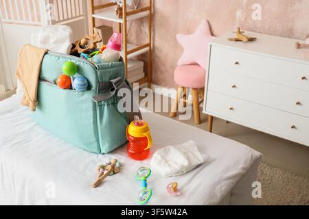 Babybeutel mit Accessoires auf dem Wickeltisch im Kinderzimmer Stockfoto