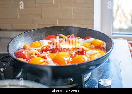 Kochen Sie Shakshuka, Menemen oder Rührei mit Tomaten in einer Bratpfanne без повторений Stockfoto