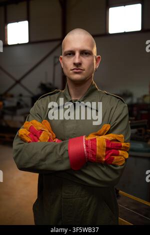 Porträt eines männlichen Schweißers, der mit verschränkten Armen in der Werkstatt steht Stockfoto