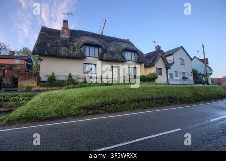 Traditionelle Strohdachhäuser auf einer grasbewachsenen Böschung am Straßenrand im historischen Dorf Finchingfield, Essex, England, UK. Stockfoto