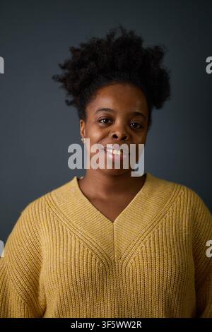 Porträt einer lächelnden jungen afrikanisch-amerikanischen Frau, die in die Kamera schaut. Bild repräsentiert soziale Vielfalt und Inklusion, ideal für Unternehmenskommunikation und HR-Marketing, vertikal Stockfoto
