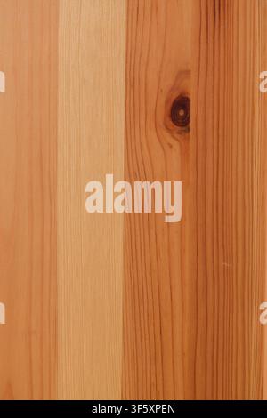 Warme Holztextur von natürlichen Brettern mit vertikaler Maserung und ausdrucksstarkem dunklem Ast. Stockfoto