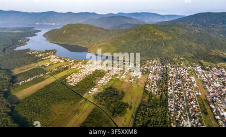 Luftaufnahme der Küstenlandschaft mit einer ruhigen Lagune, üppigen grünen Hügeln und Wohngebieten in Florianopolis, Santa Catarina, Brasilien Stockfoto