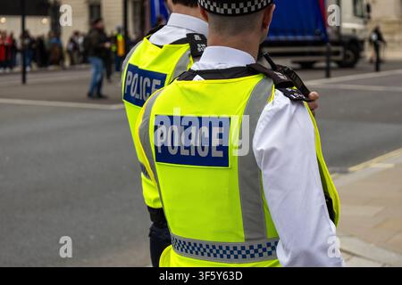 Zwei britische Polizeibeamte in Warnwesten auf der Straße Stockfoto
