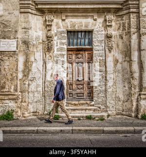 Avignon, Frankreich, 11. April 2026, Mann geht am Eingang der La Chapelle du Miracle vorbei, einer Kapelle aus dem 14. Jahrhundert, die zu Ferienwohnungen umgebaut wurde. Stockfoto