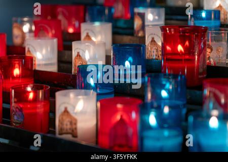 Votivkerzen in bunten roten und blauen Glasbehältern in der Kathedrale von Chartres - Kathedrale Unserer Lieben Frau von Chartres (Cathédrale Notre-Dame de Chartres). Stockfoto