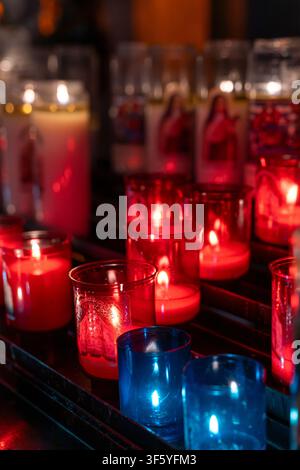 Votivkerzen in bunten roten und blauen Glasbehältern in der Kathedrale von Chartres - Kathedrale Unserer Lieben Frau von Chartres (Cathédrale Notre-Dame de Chartres). Stockfoto