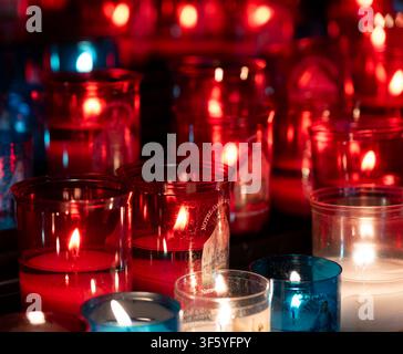 Votivkerzen in bunten roten und blauen Glasbehältern in der Kathedrale von Chartres - Kathedrale Unserer Lieben Frau von Chartres (Cathédrale Notre-Dame de Chartres). Stockfoto