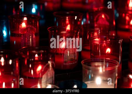 Votivkerzen in bunten roten und blauen Glasbehältern in der Kathedrale von Chartres - Kathedrale Unserer Lieben Frau von Chartres (Cathédrale Notre-Dame de Chartres). Stockfoto
