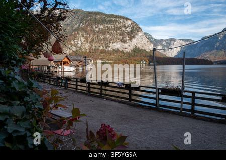 Alpensee Hallstatt, Österreich. Ein Dorf mit Holzbootshäusern und ruhigem, spiegelndem Wasser unter einem blauen Himmel. Stockfoto