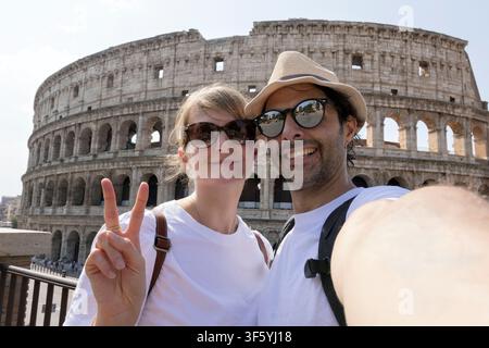 Fröhliches Paar besucht das Kolosseum in Rom, Italien. Freunde machen Selfie am Kolosseum. Stockfoto