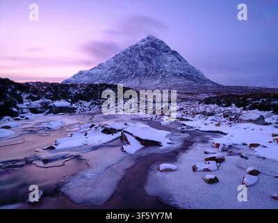 Schottland, schottische Highlands, Glencoe. Der Fluss Etive wird von dem imposanten Gipfel Buachaille Etive Mòr überragt, an einem Wintermittelalter am Abend. Stockfoto