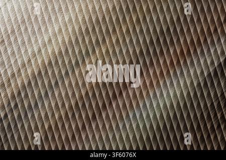 Ein abstraktes Hintergrundbild, das eine diagonale Rillenstruktur zeigt, gekennzeichnet durch eine Mischung aus erdigen Brauntönen und metallischen Grautönen. Stockfoto