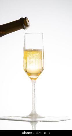 Champagner, der in ein Glas gegossen wird und einen schaumigen Überlauf erzeugt, feiert Luxus Stockfoto
