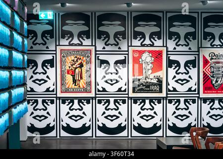 Berlin, Deutschland - 23. April 2026: Innenausstellungsraum im Urban Nation Museum mit großformatigen Shepard Fairey Obey Giant Wandgrafiken und s Stockfoto