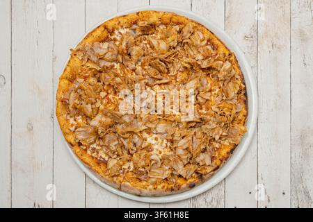 Neapolitanische Pizza mit Aubergine, frischer Rucola und Parmesan auf einem weißen Teller. Stockfoto
