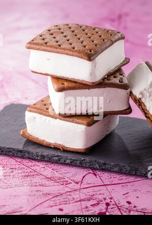 Leckere Eiscremesandwiches auf rosa Tisch Stockfoto