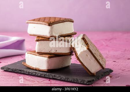 Leckere Eiscremesandwiches auf rosa Tisch Stockfoto