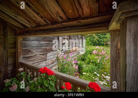 Veranda eines alten Holzhauses mit Gartenblick. Stockfoto