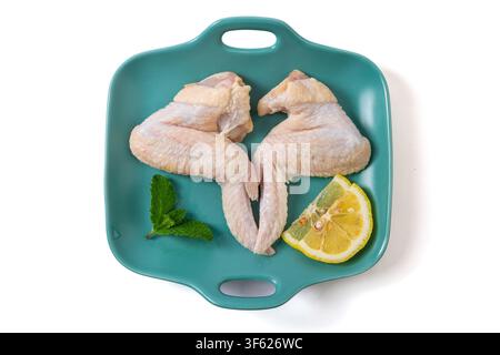 Rohe ganze Hühnerflügel auf einem Keramteller Stockfoto