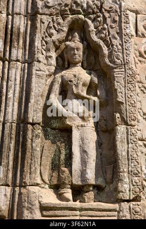 SIEM REAP, KAMBODSCHA - 2015: Eine vertikale Nahaufnahme fängt eine detaillierte Steinarbeit mit einer stehenden Devata, einer heiligen weiblichen Gottheit, auf einem Stockfoto