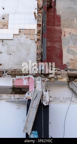 Nahaufnahme eines teilweise abgerissenen Gebäudes mit freiliegenden Ziegelmauern, Betonplatten und Bauschutt. Urbane Abriss- und Neuentwicklung in pr Stockfoto