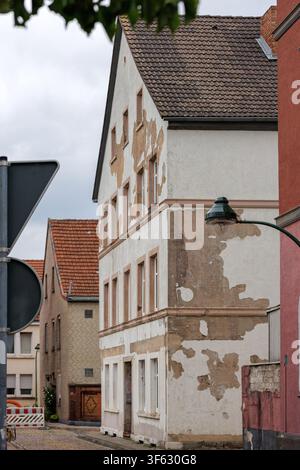 Verwitterte Fassade eines Wohngebäudes mit abblätterndem Putz in einer Altstadtstraße Stockfoto
