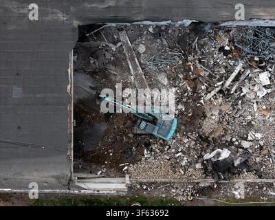 Luftaufnahme eines Baggers, der auf einer Abbruch Baustelle mit Haufen von Schutt und Trümmern in Kaunas, Kaunas County, Litauen arbeitet. Stockfoto