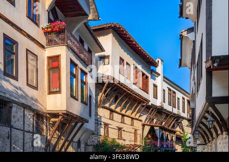 Melnik, Bulgarien. Detaillierte Straßenebenenansicht, die eine schmale Straße hinauf schaut und traditionelle weiße Steinhäuser zeigt. Stockfoto