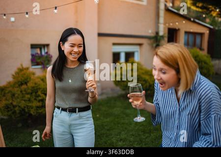 Multikulturelle Freunde haben Spaß und genießen Roséwein im Garten Stockfoto