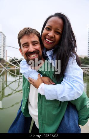 Glückliches multirassisches Paar, das draußen lächelt. Stockfoto