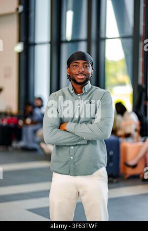 Junger afroamerikanischer Mann reist durch den Flughafen und sieht selbstbewusst aus Stockfoto