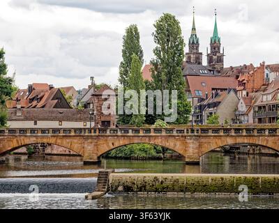 Historische Karlsbrücke Sandsteinbrücke und Flusswehr in der Altstadt von Nürnberg in Bayern in Deutschland Stockfoto