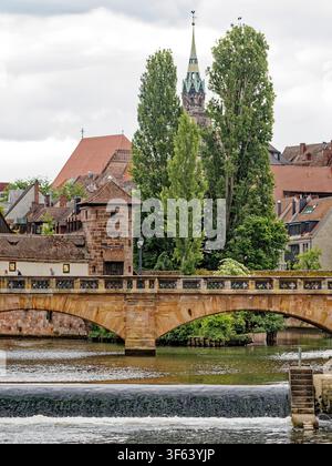 Historische Karlsbrücke Sandsteinbrücke und Flusswehr in der Altstadt von Nürnberg in Bayern in Deutschland Stockfoto