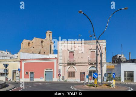 Straßenansicht mit traditionellen Gebäuden und der Kathedrale des Heiligen Vinzenz Märtyrers, die über dem historischen Zentrum von Ugento unter einem tiefblauen Himmel aufragt. Ugento, Lecce, Apulien, Italien Stockfoto
