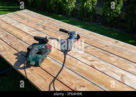 Renovierung einer alten HolzTISCHFLÄCHE im Freien mit leistungsstarken Schleifmaschinen Stockfoto