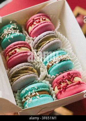 Verschiedene farbenfrohe französische Macarons in einer Papiergeschenkbox, Ansicht von oben Stockfoto