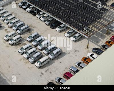 Luftbild eines Parkplatzes voller verschiedener Autos unter einem großen Solarmodul-Dach in Cebu City, Zentralvisayas, Philippinen. Stockfoto