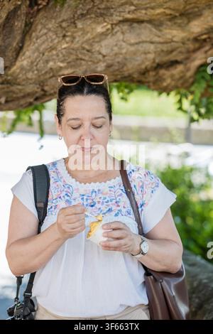 Frau genießt erfrischendes Gelato im Freien an einem Sommertag Stockfoto